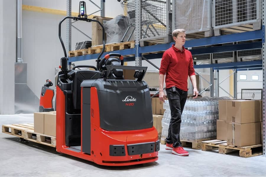 Linde medewerker loopt naast magazijntruck N20 in magazijn - Nieuwe semi-automatische bedieningsopties Linde orderpicktrucks