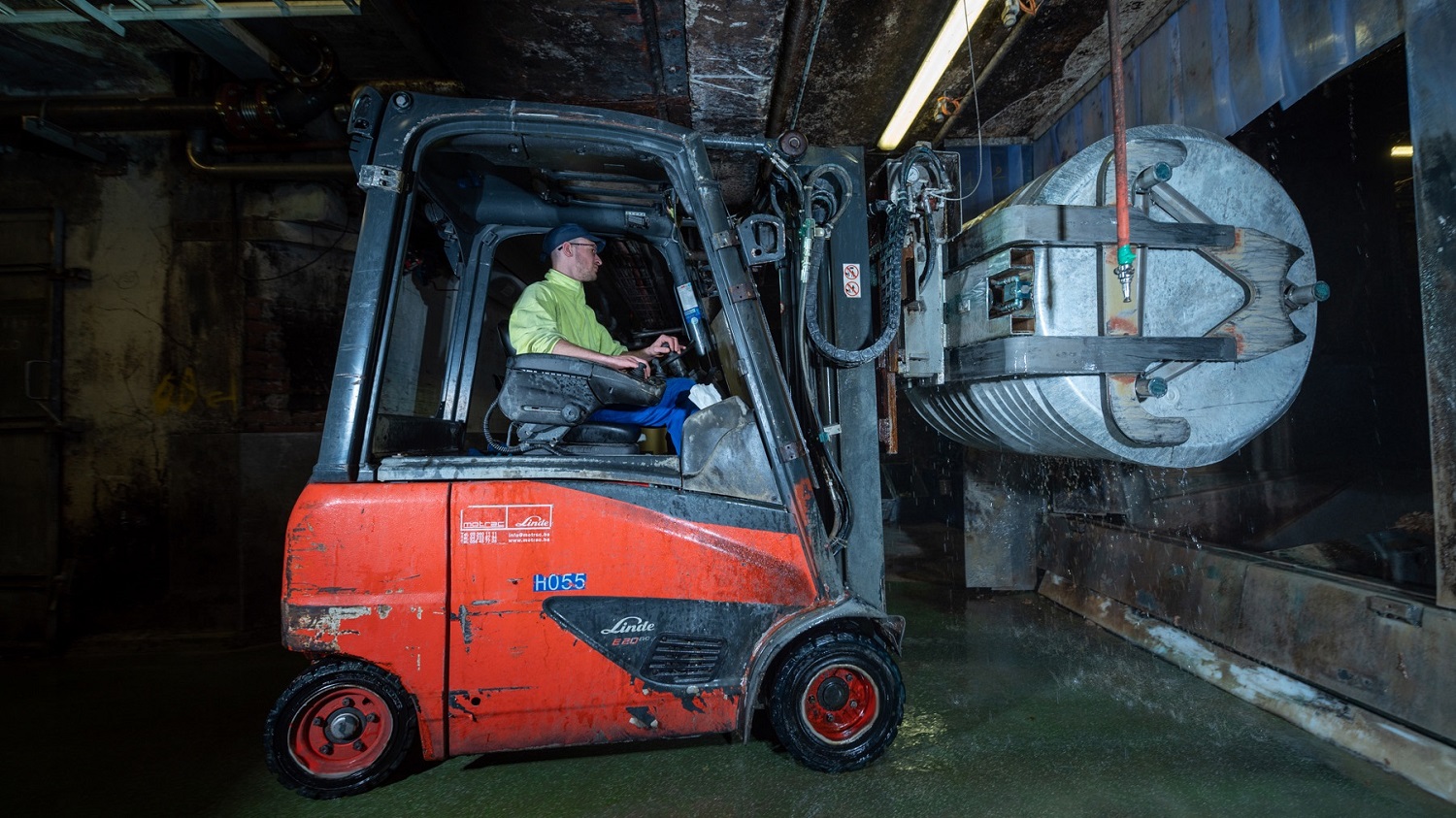 Heftruckchauffeur aan het werk met elektrische Linde heftruck E20 in zeer corrosieve omgeving