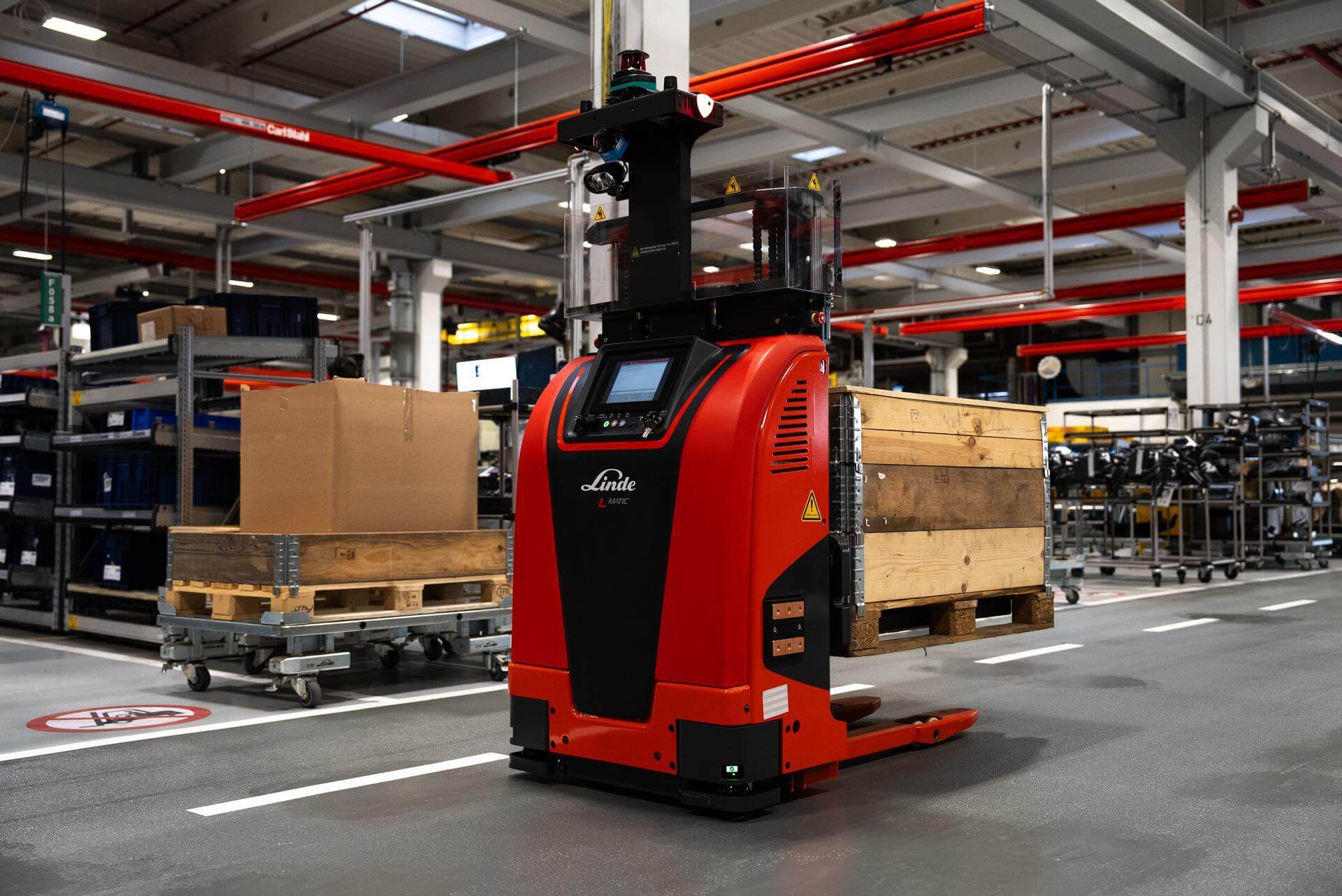 Linde L-MATIC core AGV autonome stapelaar vervoert pallet met houten kist