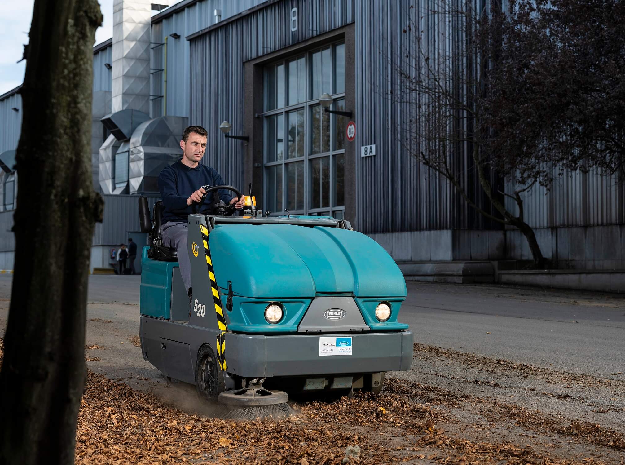 Tennant veegmachine buiten met bladeren bij Sanivest